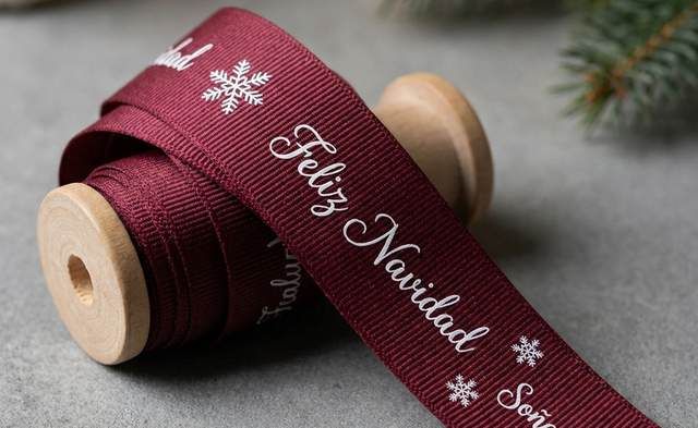 Rollo de cinta gros vino con Feliz Navidad y un copo de nieve