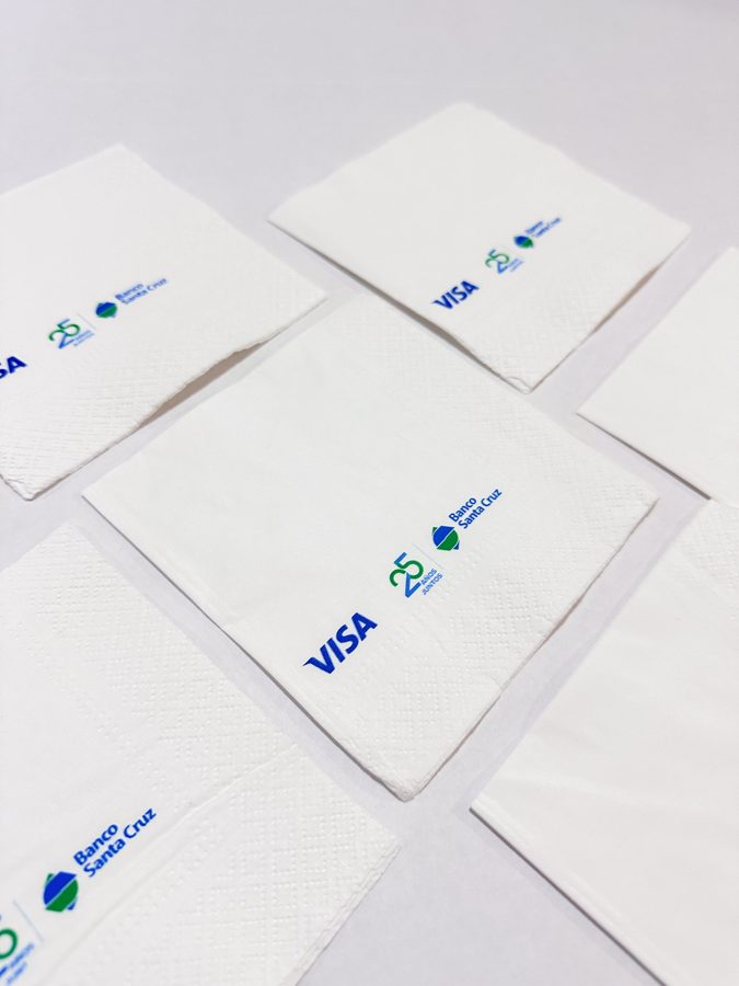 Servilletas blancas con logos corporativos impresos en azul y verde