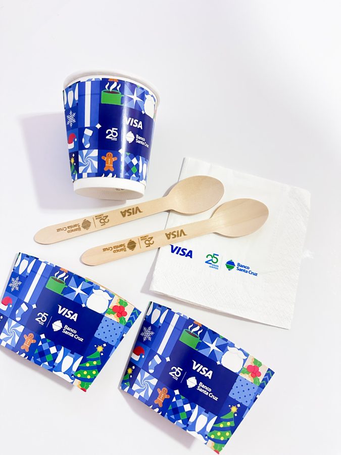 Vaso de papel con su manga, cucharas de madera y una servilleta con diseño navideño corporativo en azul