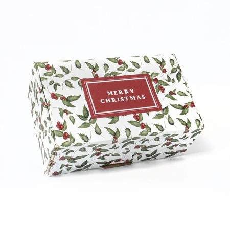 Caja blanca con hojas de acebo y bayas y una etiqueta Merry Christmas